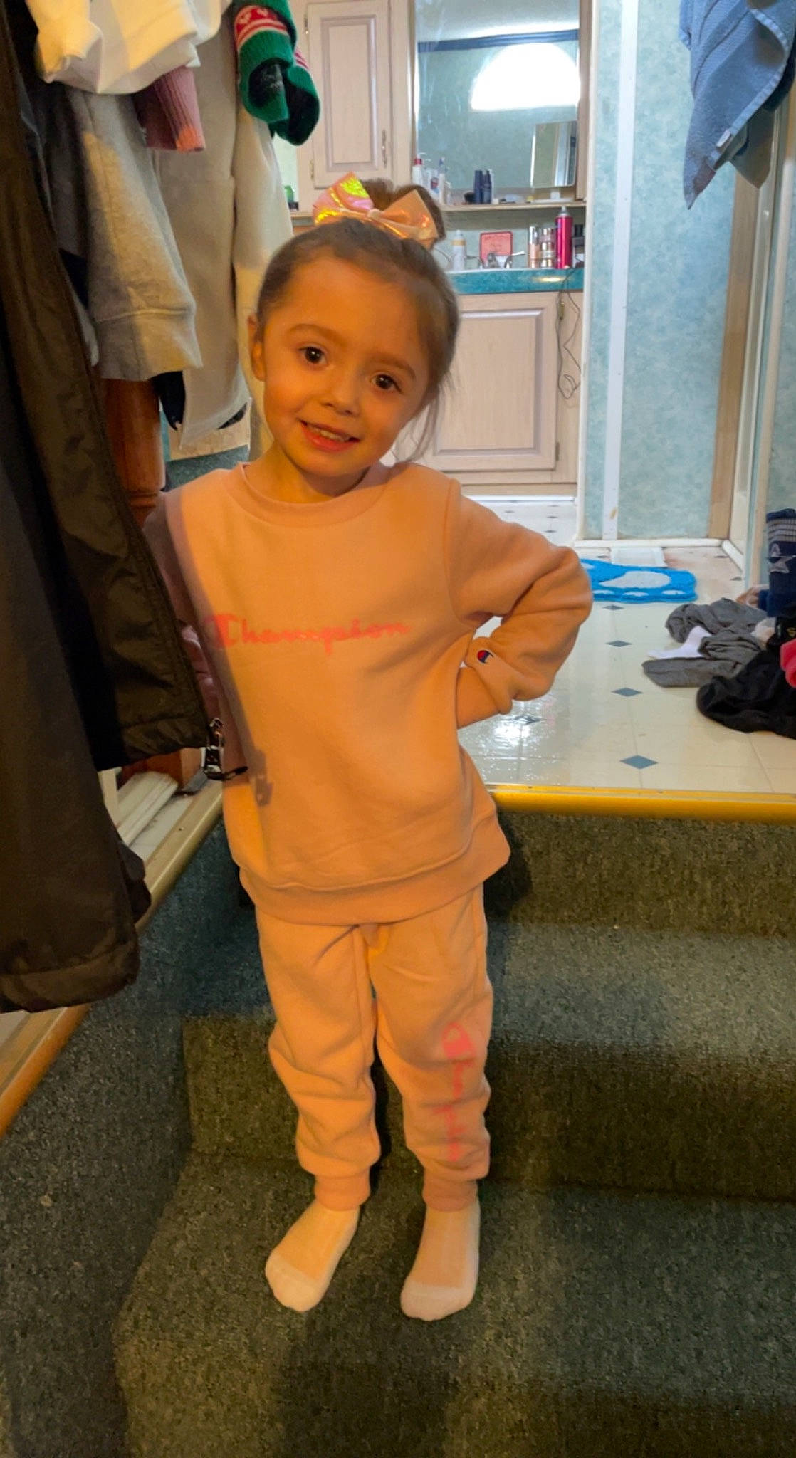 Kaelyn is registered to the contest to win money with this photo: abdomen, bag, child, eye, flooring, formal_wear, fun, gesture, human_leg, joy, knee, luggage_and_bags, person, room, sleeve, smile, suit, thigh, thumb, toddler