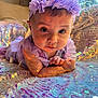 baby, child, headband, purple, sparkling, sequins, fabric, indoor, cute, face, hands, lying_down, clothing, light_reflection, pattern, infant, portrait, young_child, colorful, closeup