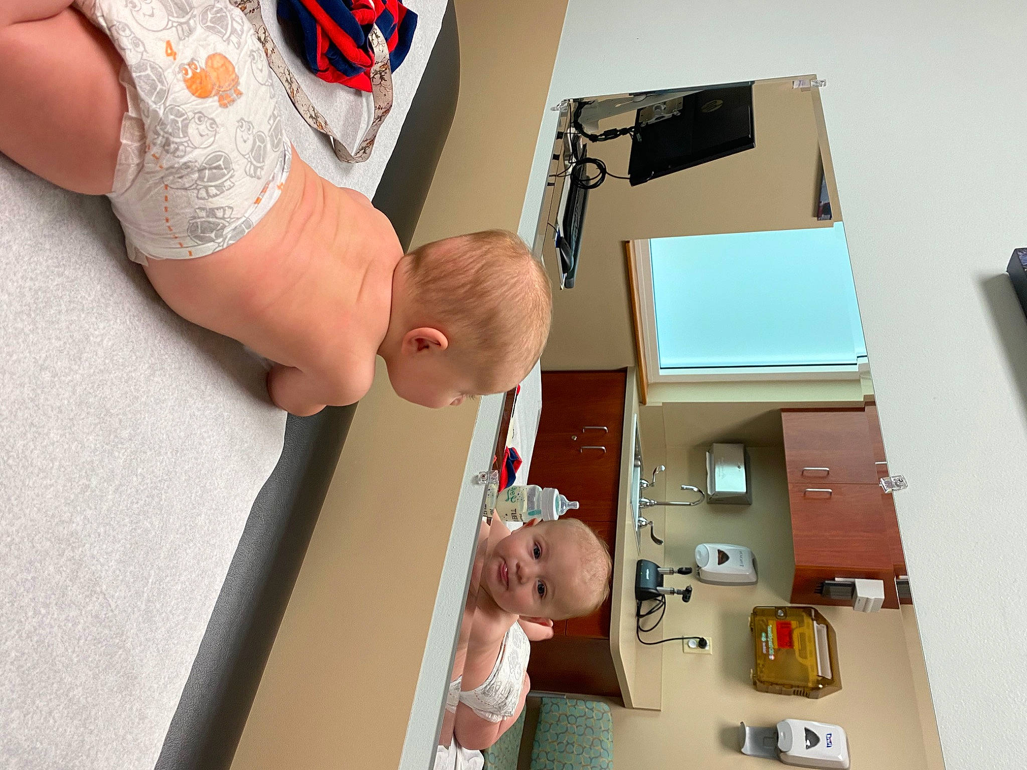 Philip is registered to the contest to win money with this photo: arm, baby, box, cardboard, carton, child, desk, elbow, finger, floor, flooring, foot, human_leg, joint, person, room, shipping_box, table, thigh, toddler