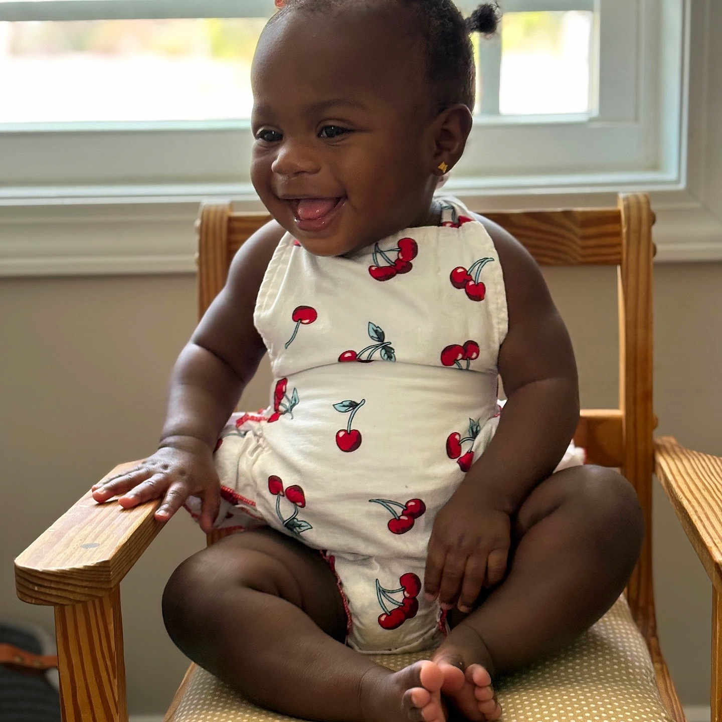 Charlotte is registered to the contest to win money with this photo: baby, chair, cherry_pattern, child, cute, foot, hair_bows, hand, happy, indoor, natural_light, outfit, polka_dot, portrait, sitting, skin, smiling, toddler, window, wooden_chair