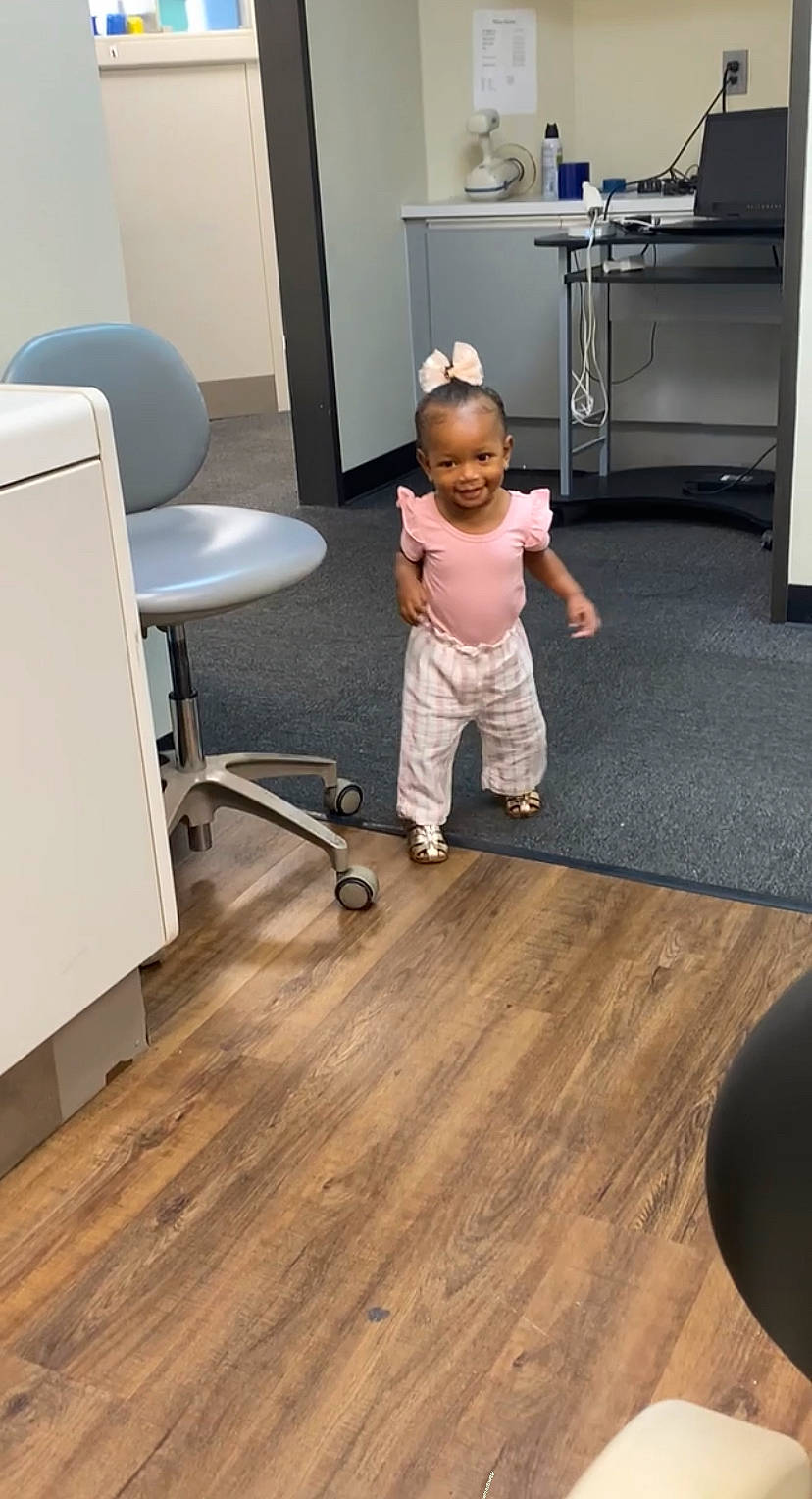 Abigail is registered to the contest to win money with this photo: cabinetry, child, cleanliness, comfort, drawer, floor, flooring, hardwood, interior_design, joy, laminate_flooring, leg, person, plywood, room, standing, table, toddler, varnish, wood