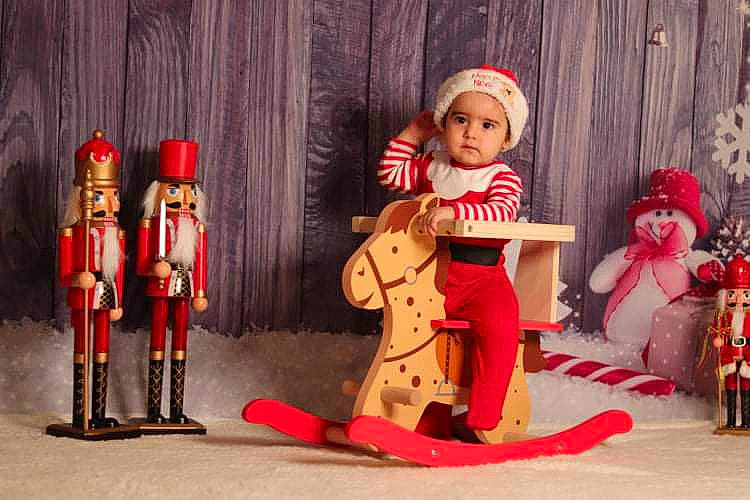 Sacha participe au concours pour gagner de l'argent avec cette photo : art, carmine, christmas, christmas_decoration, decorative_nutcracker, doll, entertainment, event, fun, headwear, musical_instrument, musician, performing_arts, person, plucked_string_instruments, red, sitting, string_instrument, toy, tradition