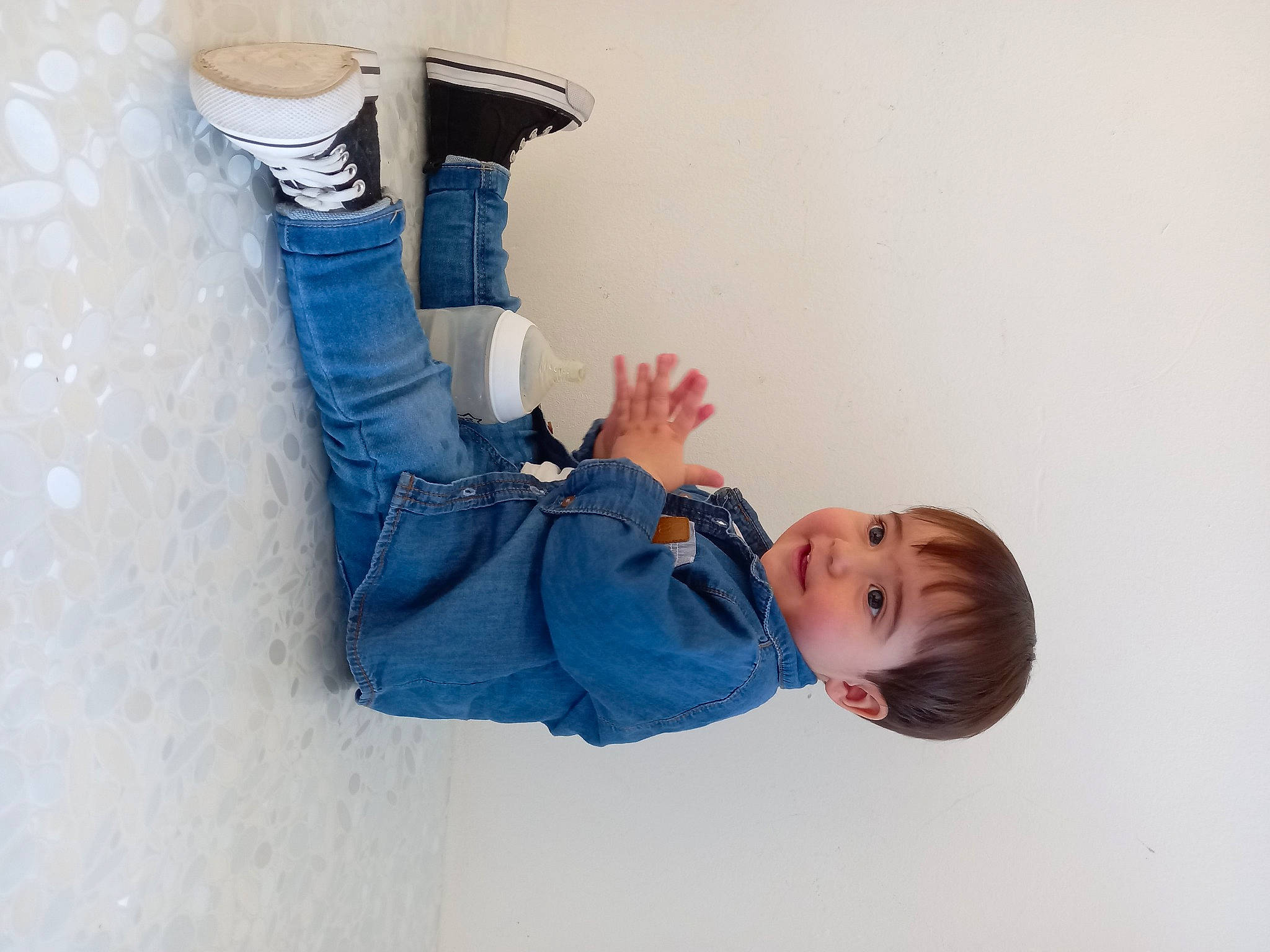 Sacha participe au concours pour gagner de l'argent avec cette photo : comfort, denim, elbow, electric_blue, fun, gesture, glove, happy, human_leg, jeans, knee, leisure, person, sitting, sleeve, sneakers, sock, t_shirt, thigh, toddler