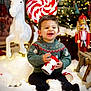 Ilyas participe au concours pour gagner de l'argent avec cette photo : child, toddler, smiling, holiday, christmas, sweater, festive, toy, rocking_horse, nutcracker, candy, lights, snow, decorations, indoor, happy, playing, can, seasonal, celebration
