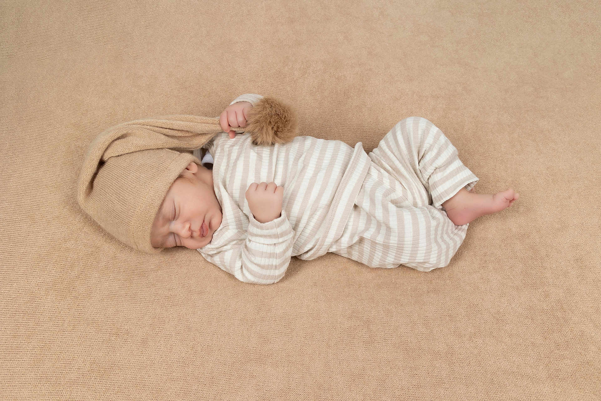 Louka a rejoint le concours — aidez-le/la à gagner de superbes lots ! baby, sleeping, infant, pajamas, striped_clothing, knit_hat, beige, blanket, soft_texture, peaceful, newborn, portrait, cozy, resting, child, one_person, indoors, cute, small_hands, small_feet