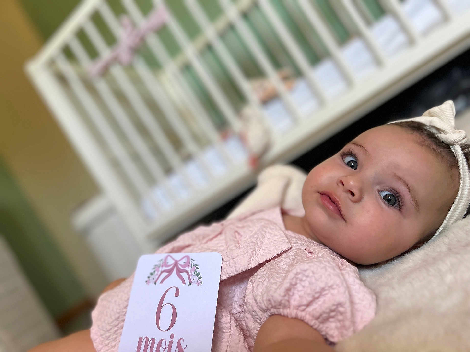 Angélina a rejoint le concours — aidez-le/la à gagner de superbes lots ! baby, infant, child, pink_clothing, headband, crib, soft_texture, lying_down, indoors, portrait, cute, young_child, face, eyes, skin, sleepwear, decor, blurred_background, six_months, relaxed