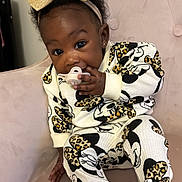 Khalani is registered to the contest to win money with this photo: baby, bow, chair, child, clothing, cute, earring, fashion, happy, headband, indoor, leopard_print, mickey_mouse, pacifier, person, plush, portrait, sitting, smiling, toddler