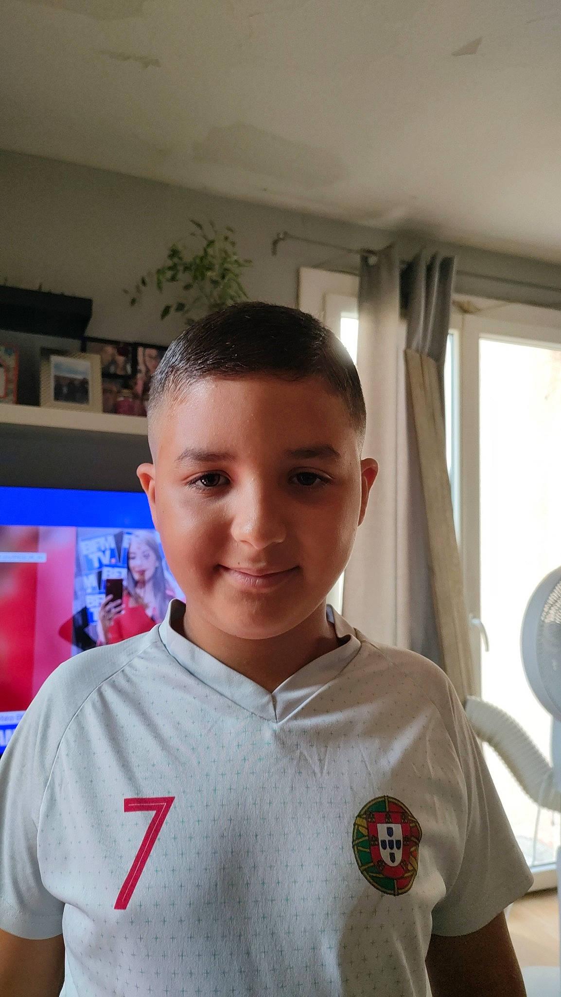 Yanis participe au concours pour gagner de l'argent avec cette photo : aerospace_engineering, blurred, buzz_cut, caesar_cut, crew_cut, curtain, fun, gesture, houseplant, job, joy, logo, mechanical_fan, person, room, sleeve, smile, t_shirt, television, uniform