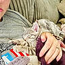 kitten, cat, sleeping, person, glasses, hand, blanket, couch, cozy, nap, pet, indoor, comfort, furniture, clothing, tattoo, pink_nail_polish, striped_shirt, closeup, relaxation