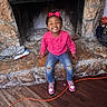 Jaliyah is registered to the contest to win money with this photo: accessory, candid, casual_clothing, child, fireplace, girl, happy, home_interior, indoor, joyful, pink_bow, pink_sweatshirt, playful, ripped_jeans, seated, smiling, sneakers, stone_hearth, wood_floor, young_person