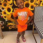 Jaliyah joined the competition — help win amazing prizes! child, girl, smile, orange_clothing, sunflowers, flower_wall, sneakers, standing, happy, portrait, indoor, fashion, cute, hair_buns, tiled_floor, striped_chair, hands_on_hips, colorful, playful, youth