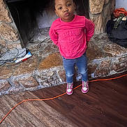 Jaliyah is registered to the contest to win money with this photo: bow, casual_clothing, child, confident, cozy, cute, extension_cord, fireplace, girl, hands_behind_back, home, indoor, jeans, pink_sweatshirt, portrait, pout, sneakers, standing, stone_wall, wood_floor