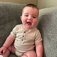 Rhett is registered to the contest to win money with this photo: baby, child, smiling, couch, indoor, onesie, socks, happy, cute, infant, person, seated, plump, face, skin, head, arm, leg, furniture, cozy