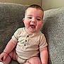 baby, child, smiling, couch, indoor, onesie, socks, happy, cute, infant, person, seated, plump, face, skin, head, arm, leg, furniture, cozy