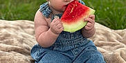 Bentley joined the competition — help win amazing prizes! baby, child, watermelon, denim_overalls, blanket, grass, outdoor, summer, food, fruit, cute, sitting, barefoot, eating, portrait, greenery, happy, skin, infant, nature