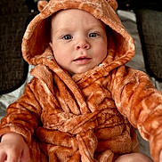 Axl is registered to the contest to win money with this photo: baby, child, infant, hood, robe, orange, fuzzy, soft, cute, ears, clothing, sitting, portrait, face, eyes, hand, skin, indoor, warm, comfort