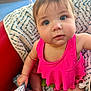 Emmy joined the competition — help win amazing prizes! baby, child, infant, pink_clothing, blanket, red_chair, blue_pattern, indoors, sitting, curious, face, wide_eyes, closeup, person, cute, skin, head, hand, foot, expression