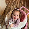 baby, baby_walker, bow, child, clothing, cute, feeding, hair_accessory, happy, holding, indoor, infant, milk_bottle, person, pink, portrait, sitting, smiling, white, wooden_floor