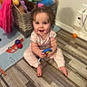 Jourdyn is registered to the contest to win money with this photo: baby, basket, bright, child, clothing, curly_hair, cute, floor, flooring, happy, indoor, person, pink_pants, playtime, room, sitting, smiling, stuffed_animals, toy, wooden_floor