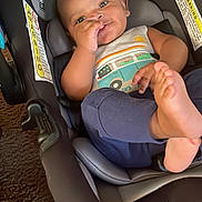 Jahlil is registered to the contest to win money with this photo: baby, blue_pants, car_seat, car_seat_strap, child, clothing, cute, face, foot, head, indoor, infant, padded_seat, relaxed, seat_belt, skin, smiling, tank_top, thumb_sucking, warning_label