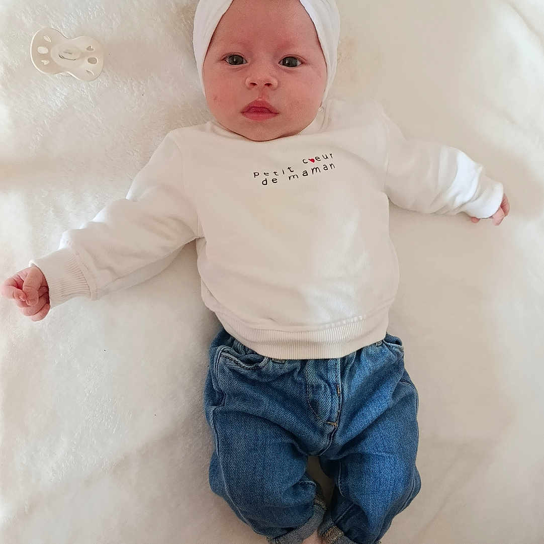 Ezya participe au concours pour gagner de l'argent avec cette photo : baby, infant, headband, white_sweatshirt, blue_jeans, pacifier, blanket, soft_texture, lying_down, cute, calm, indoors, child, newborn, fashion, cozy, portrait, clothing, baby_girl, headwear