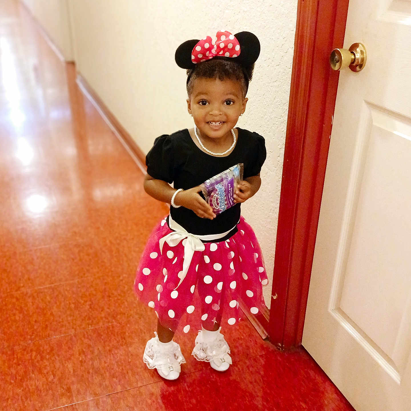 Eliana is registered to the contest to win money with this photo: accessories, bracelet, child, clothing, costume, door, dress, face, female, footwear, girl, hardwood, head, jewelry, necklace, person, photography, portrait, skirt, wood