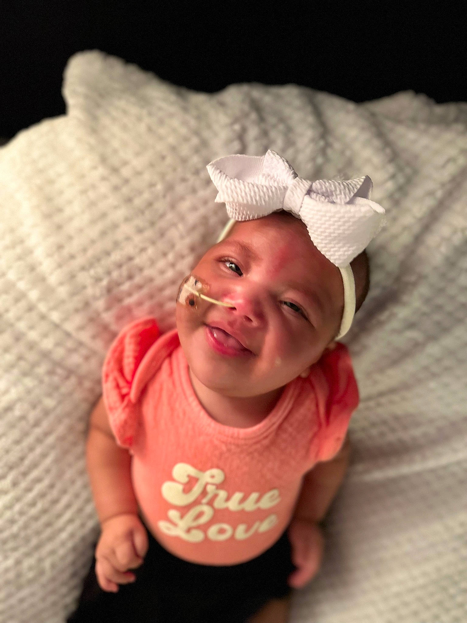 Ailani is registered to the contest to win money with this photo: baby, baby_toddler_clothing, cap, cheek, child, comfort, face, fashion_accessory, flash_photography, happy, headgear, headwear, linens, lip, magenta, person, pink, skin, sleeve, smile