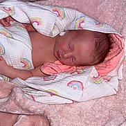 Layla is registered to the contest to win money with this photo: newborn, baby, sleeping, blanket, rainbow_pattern, pink, soft_texture, wrapped, infant, cozy, resting, human, skin, head, peaceful, cute, child, indoors, comfort, toddler