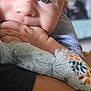 baby, blanket, chewing, child, close_up, cozy, cute, expression, eyes, face, fingers, hand, indoor, infant, natural_light, pattern, portrait, skin, soft, young