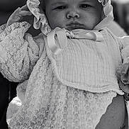 Love is registered to the contest to win money with this photo: baby, infant, lace, bonnet, clothing, portrait, black_and_white, closeup, face, hand, adult, tattoo, holding, person, cute, expression, soft_light, fabric, texture, newborn