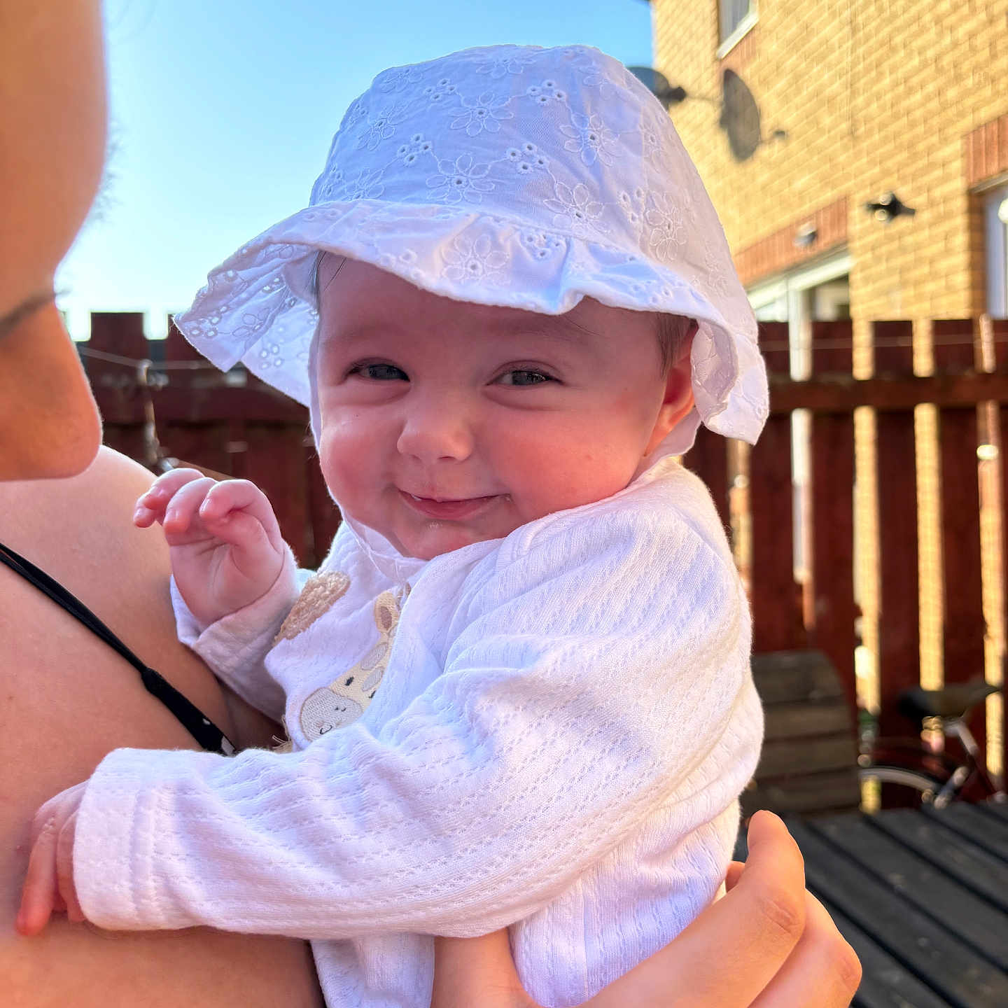 Ava is registered to the contest to win money with this photo: adult, baby, bicycle, bodypart, bonnet, cap, clothing, face, female, finger, hand, hat, head, person, photography, portrait, sunhat, transportation, vehicle, woman