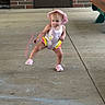 Chloe joined the competition — help win amazing prizes! toddler, child, pink_hat, swimsuit, concrete_floor, brick_wall, door, playful, pose, summer, outdoor, footwear, pink_shoes, colorful_clothing, young_child, person, casual, sidewalk_chalk, bench, determined