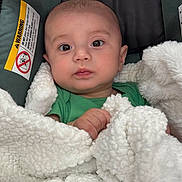 ángel is registered to the contest to win money with this photo: baby, infant, child, portrait, face, eyes, wide_eyed, looking_at_camera, sitting, car_seat, blanket, white_blanket, green_shirt, plush, cozy, indoor, close_up, photography, warning_label, safe