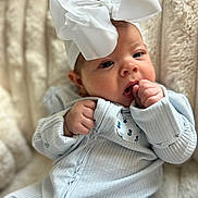 Maggie Mae joined the competition — help win amazing prizes! baby, infant, face, hand, headband, bow, clothing, onesie, sitting, blanket, soft, cute, portrait, skin, expression, indoors, child, newborn, young, comfort