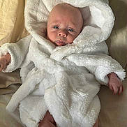 Cassius is registered to the contest to win money with this photo: baby, infant, robe, white, fluffy, hood, ears, bed, blanket, skin, face, legs, arms, cute, cozy, lying, soft, child, indoors, sleepwear