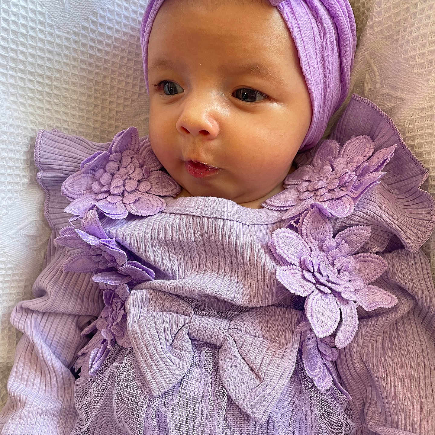 Aurora is registered to the contest to win money with this photo: baby, blanket, bow, child, closeup, cute, face, flowers, hands, headwrap, indoors, infant, lace, newborn, portrait, purple_clothing, skin, sleepwear, soft_texture, tulle