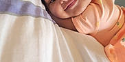 Jurnee is registered to the contest to win money with this photo: baby, child, smile, face, hair_bow, curly_hair, bed, pillow, blanket, clothing, infant, portrait, cute, happy, lying_down, indoors, soft_light, pastel_colors, peaceful, young