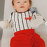 baby, child, infant, puma, clothing, red_pants, striped_shirt, lying_down, face, freckles, sparkles, digital_effect, cute, portrait, indoor, soft_lighting, toy, pacifier, hands_covered, white_background