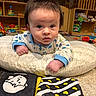 Kayson joined the competition — help win amazing prizes! baby, infant, pillow, toy, book, carpet, playroom, shelf, furniture, child, clothing, floor, indoor, cute, curious, face, hands, eyes, expression, soft