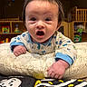 Kayson is registered to the contest to win money with this photo: baby, infant, pillow, onesie, expression, surprised, toy, crib, shelf, room, child, face, hand, indoor, closeup, cursive, pattern, colorful, cute, softlighting