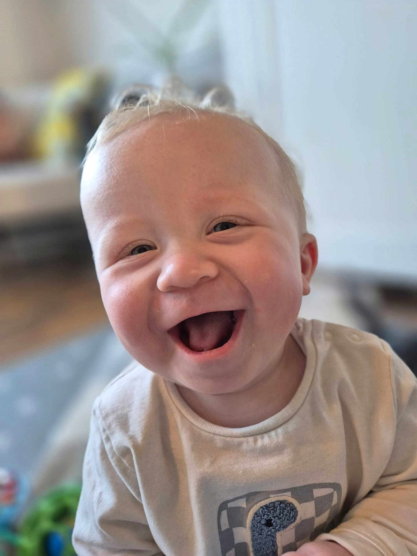 Zach is registered to the contest to win money with this photo: baby, smiling, child, infant, face, happy, mouth_open, indoor, clothing, cute, portrait, person, young_child, blonde_hair, cheerful, closeup, toddler, soft_light, casual, background_blur