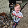 blond_hair, chair, child, denim_shorts, driveway, garden, gray_shirt, happy, house, outdoor, pebbles, playtime, porch, portrait, potted_plant, pottery, rocks, scooter, smiling, toddler
