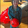 child, bowling_ball, bowling_alley, denim_jacket, jeans, smiling, indoor, wooden_floor, people, shoe, adult, group, recreation, sport, happy, leisure, casual_clothing, red, standing, young