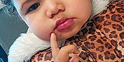 Serenity joined the competition — help win amazing prizes! toddler, child, curly_hair, face, finger_on_cheek, leopard_print, vest, purple_sweater, indoor, expression, cute, young_child, portrait, warm_clothing, fur_trim, button, skin, hand, looking_down, closeup