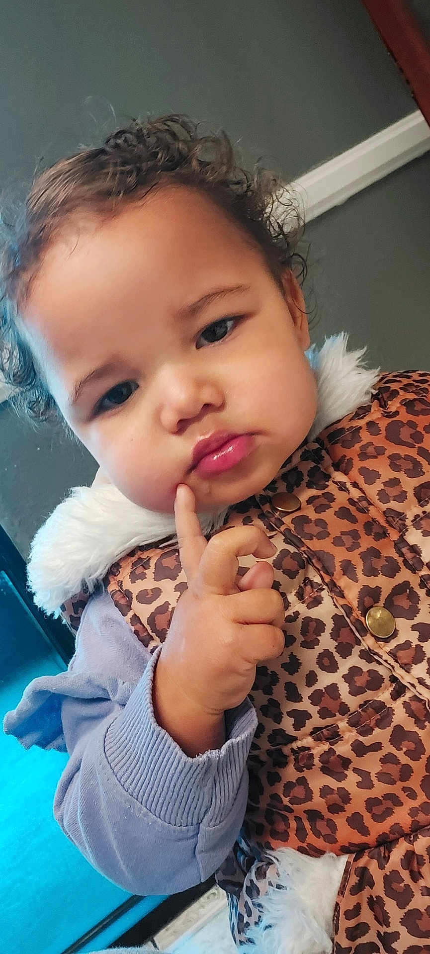 Serenity joined the competition — help win amazing prizes! toddler, child, curly_hair, face, finger_on_cheek, leopard_print, vest, purple_sweater, indoor, expression, cute, young_child, portrait, warm_clothing, fur_trim, button, skin, hand, looking_down, closeup