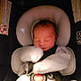 baby, car_seat, newborn, sleeping, infant, seatbelt, mitten, child, padded_seat, soft_lighting, indoors, safety, resting, cute, tiny_hand, wrapped, peaceful, person, closeup, portrait