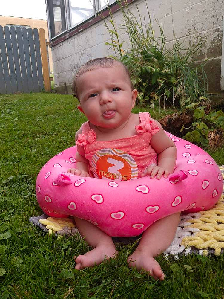 Alize is registered to the contest to win money with this photo: baby, baby_products, baby_toddler_clothing, child, fun, games, garden, grass, inflatable, lawn, person, pink, plant, sitting, toddler, yard