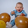 baby, balloon, balloons, blue_clothing, celebration, child, face, foot, hands, happy, photography, playful, portrait, sitting, smile, sock, studio, sweater, toddler, white_background