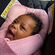 Kanyla is registered to the contest to win money with this photo: baby, infant, child, smiling, happy, face, portrait, curly_hair, car_seat, pink, blanket, pacifier, baby_carrier, sitting, indoors, vehicle, safe, close_up, head, photography