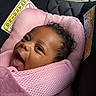 baby, infant, child, smiling, happy, face, portrait, curly_hair, car_seat, pink, blanket, pacifier, baby_carrier, sitting, indoors, vehicle, safe, close_up, head, photography